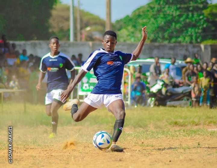 Jeune joueur déclenchant une frappe pendant un match de la Ouidah Cup.