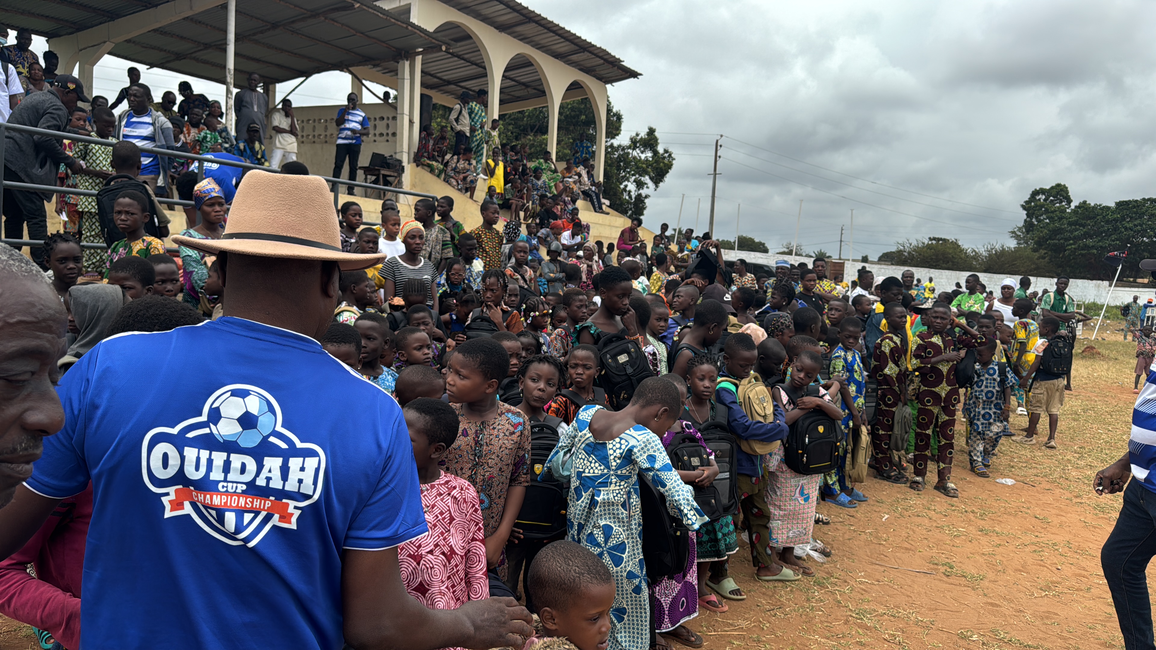 Enfants rassemblés avec des sacs scolaires lors d'une action solidaire de ESD.